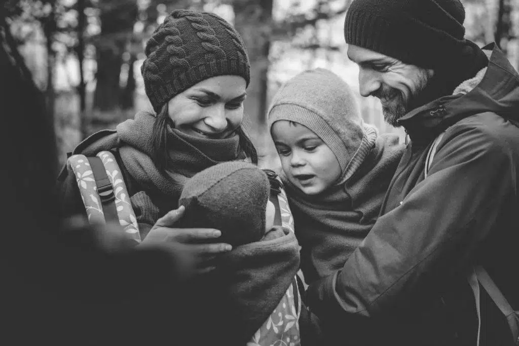 Familie beim Waldspaziergang umarmt sich Detail schwarz weiß