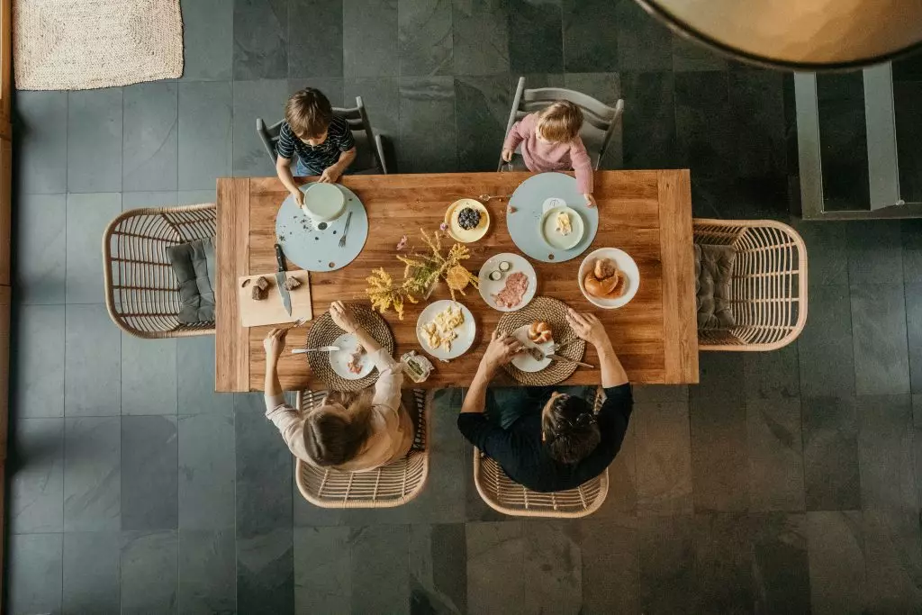Familienreportagen - authentische Familienfotos - Die ganze Familie am Fr&uuml;hst&uuml;ckstisch zu Hause aus der Draufsicht