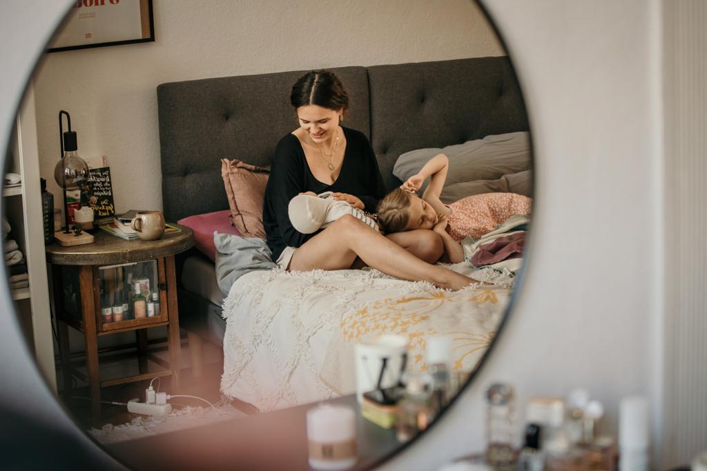Die ersten dokumentarischen Familienfotos mit Baby zuhause in Berlin - Mama stillt ihr Neugeborenes im Wochenbett