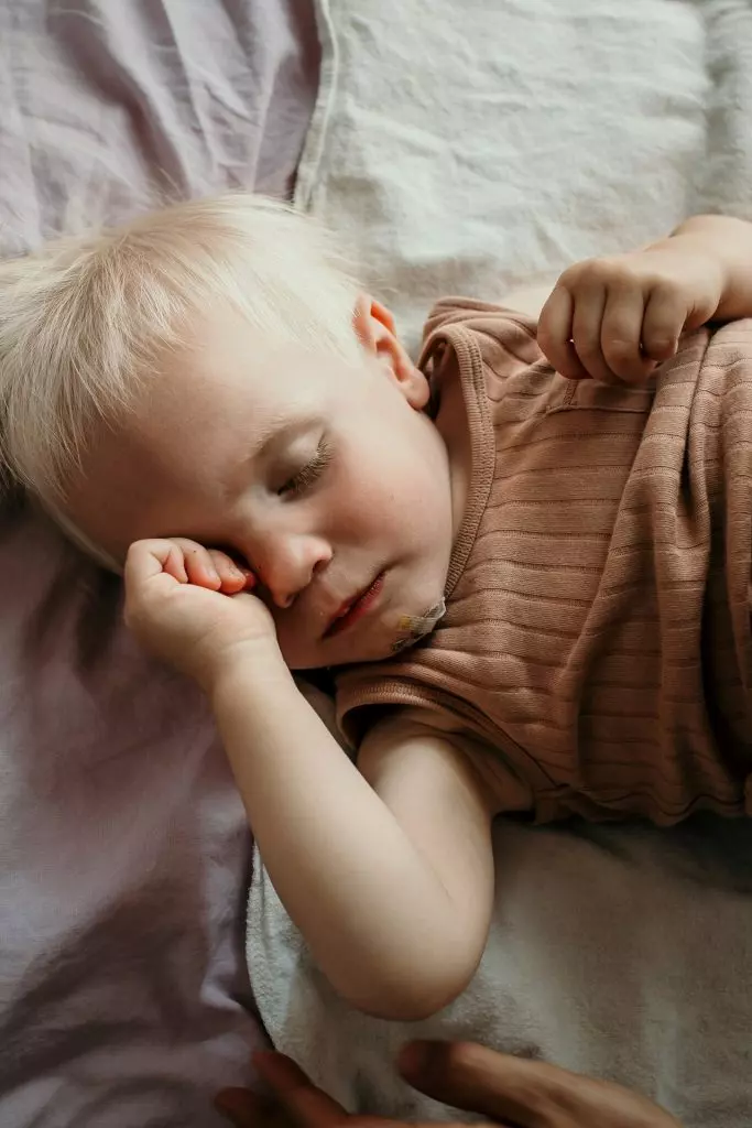 junge muede schlaeft bett zuhause