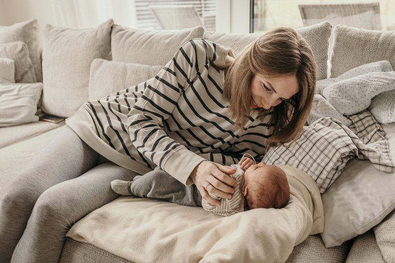 Wochenbett Fotografie in Berlin - Eine Mama schaut glücklich ihr Baby an