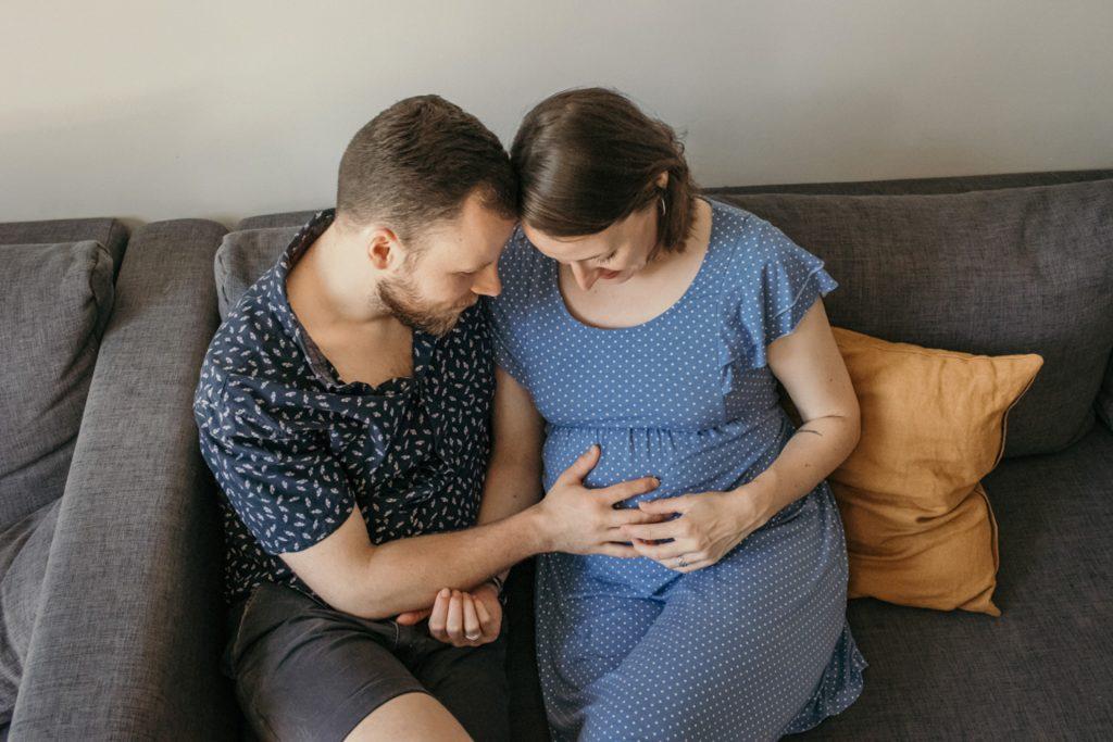dokumentarische-Babyauchfotografie in Berlin Prenzlauer Berg und Friedrichshain - Ein Mann hält liebevoll den Babybauch seiner Frau
