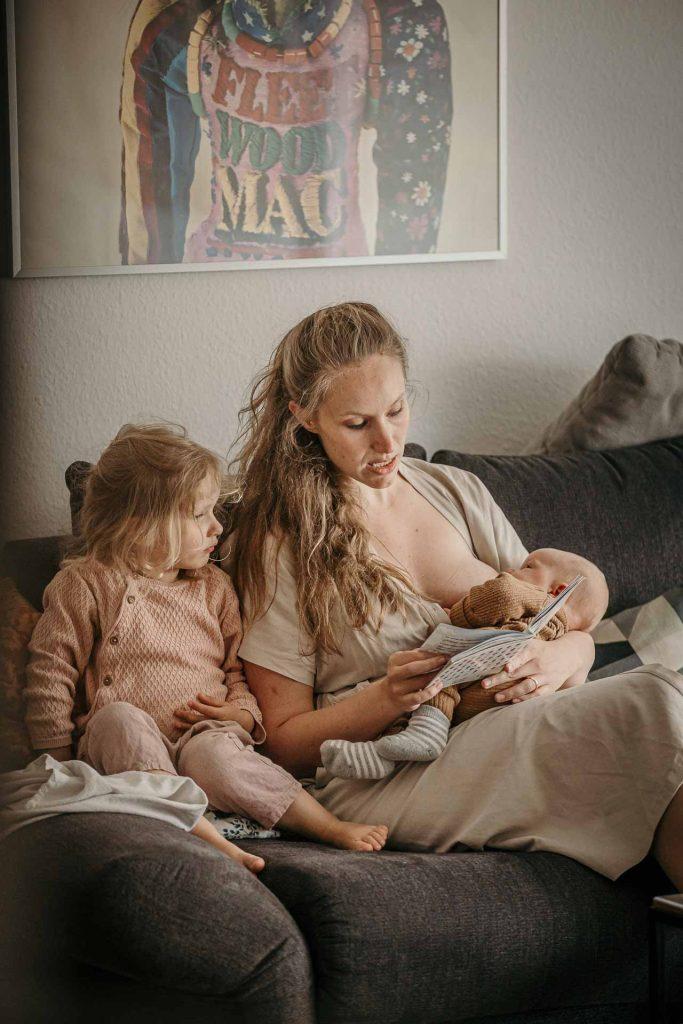 neugeborenenfotos berlin mama tochter buch vorlesen baby arm couch