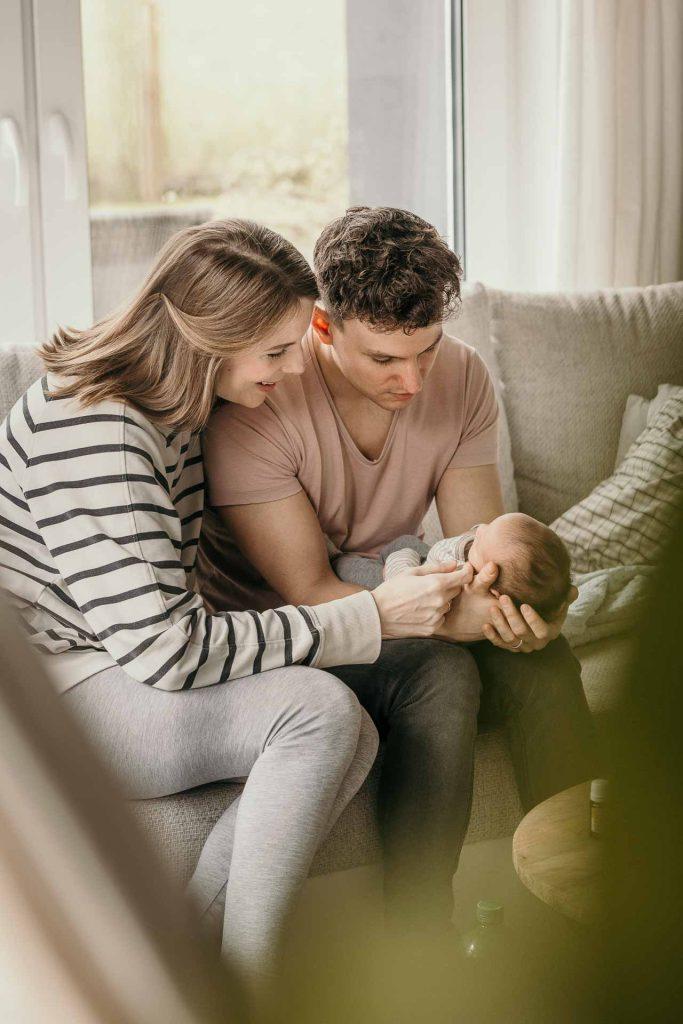 newborn fotografie berlin eltern couch baby schoss streicheln